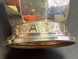 a close up of a silver cup with a name on it