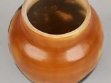 a brown vase sitting on a table with a white background