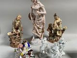 cinq figurines posées sur une table, sur fond blanc