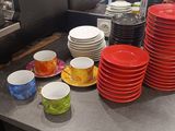 de nombreuses assiettes et tasses posées sur le plan de travail de la cuisine