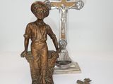 a statue of a woman holding a basket next to a cross and a crucift