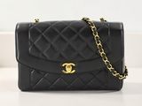 un sac Chanel noir avec des finitions dorées et une chaîne