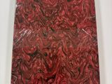 red and black marbled paper on a white surface