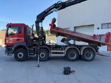 un camion rouge équipé d'une grue à l'arrière