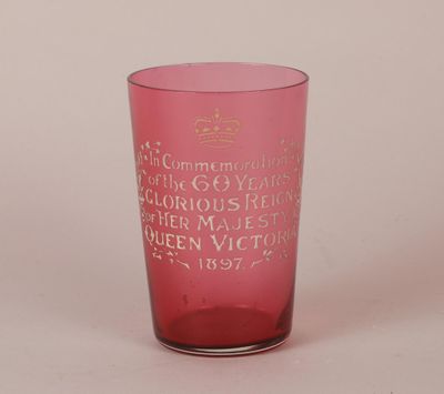 pink glass with writing on it sitting on a white surface