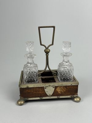 a small wooden box with two glass decanters on it