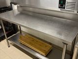 une table de travail en acier inoxydable sur laquelle est posé un micro-ondes
