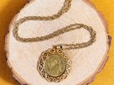 collier composé d'une chaîne en or et d'une pièce de monnaie sur fond jaune