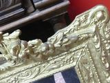 a gold frame sitting on a marble floor next to a red wall