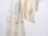 three white dresses hanging on a clothes rack against a white wall
