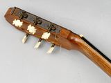 a close up of a guitar neck with four strings and a tuner