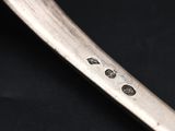 close up of a knife with holes in it on a black surface