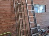 two ladders leaning against a wooden wall in a room