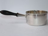 a silver saucepan with a black handle on a white surface