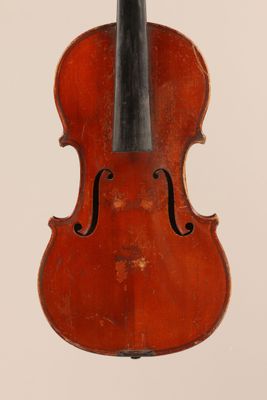 un vieux violon posé sur une surface blanche