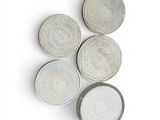 four white plates with designs on them on a white surface