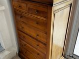 a wooden chest of drawers with a laptop on top of it