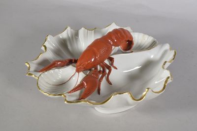 a red lobster in a shell shaped dish on a white table
