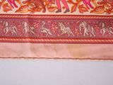 a picture of a pink and orange scarf with a picture of a man riding a horse