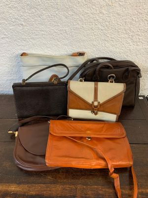 trois porte-monnaie et un sac à main posés sur une table en bois