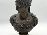 a bronze bust of a woman wearing a headdress on a wooden base