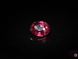 a close up of a pink diamond on a black surface