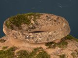 a stone bowl sitting on top of a rock covered in moss