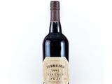 a bottle of red wine sitting on top of a white table