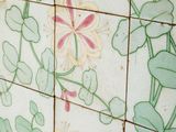 a tiled wall with flowers and vines on it