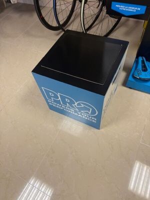 une boîte posée par terre à côté d'un vélo