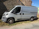 une camionnette argentée garée devant un immeuble