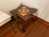 a small wooden table with a chess board on it