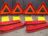 quatre panneaux d'avertissement rouges et jaunes posés sur un sol en béton