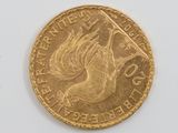 a close up of a gold coin on a white surface