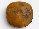 an oval bronze box with stars on it