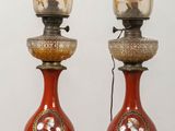 two red vases sitting on top of a wooden table