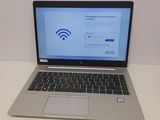 un ordinateur portable posé sur une table, avec le symbole du Wi-Fi affiché à l'écran