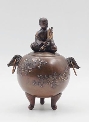 une petite statue représentant une personne assise sur un pot