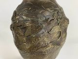 brass plated vase with a bird on it on a stand
