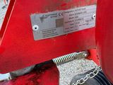 a close up of a red tractor with a chain attached to it