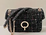 sac à main en tweed noir et blanc avec une bandoulière en chaîne dorée