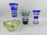 quatre vases en verre de couleurs différentes posés sur une surface blanche
