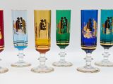 seven different colored wine glasses lined up in a row