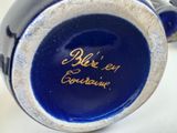 a close up of a blue vase with writing on it