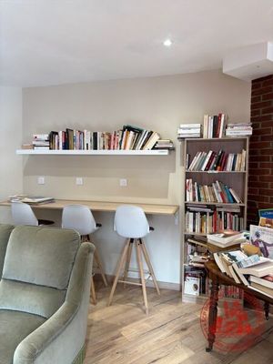 un salon avec un canapé, une table et une bibliothèque