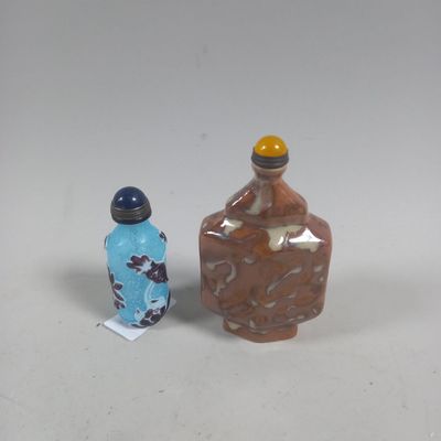 deux petites bouteilles posées l'une à côté de l'autre sur une table