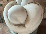 a statue of a flower in a bucket on the ground