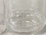 a glass of water with a spoon next to it