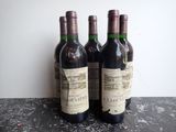 three bottles of wine sitting on top of a table next to a bottle of wine