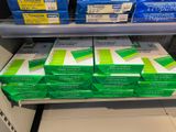 many boxes of toothpaste on a shelf in a store